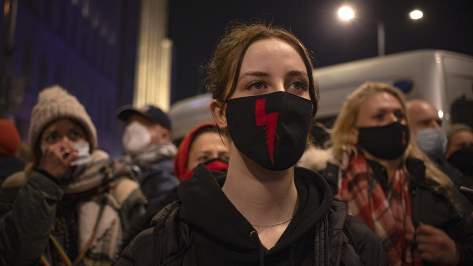 Demonstrators wear masks with the red lightning bold, a symbol of the pro-choice movement, during a protest against a top court ruling restricting abortions in Warsaw, Poland, Wednesday, Nov. 18, 2020. The upheaval began when the constitutional court, packed with loyalists of the conservative ruling party, ruled Oct. 22 to ban abortions in cases of congenital fetal defects, even if the fetus has no chance of survival. (AP Photo/Agata Grzybowska)