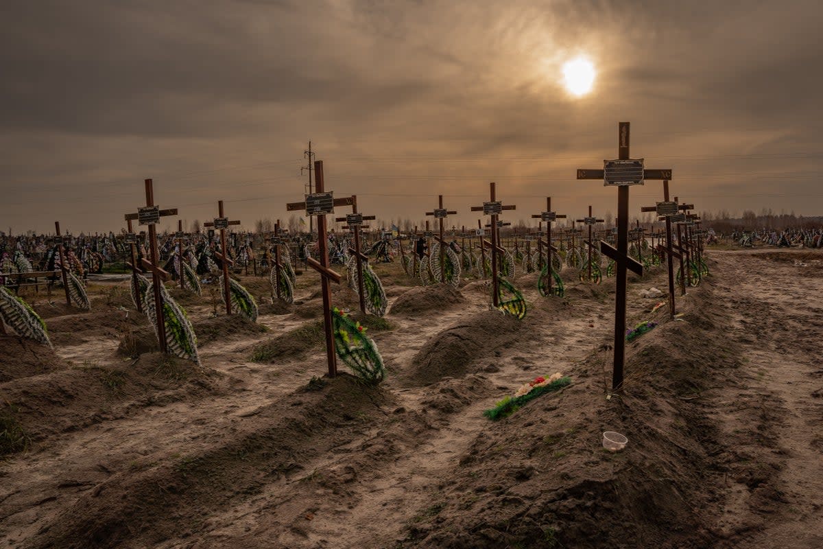 A graveyard of unidentified bodies in Bucha, where Russian troops were accused of summarily executing Ukrainians (Bel Trew/The Independent)