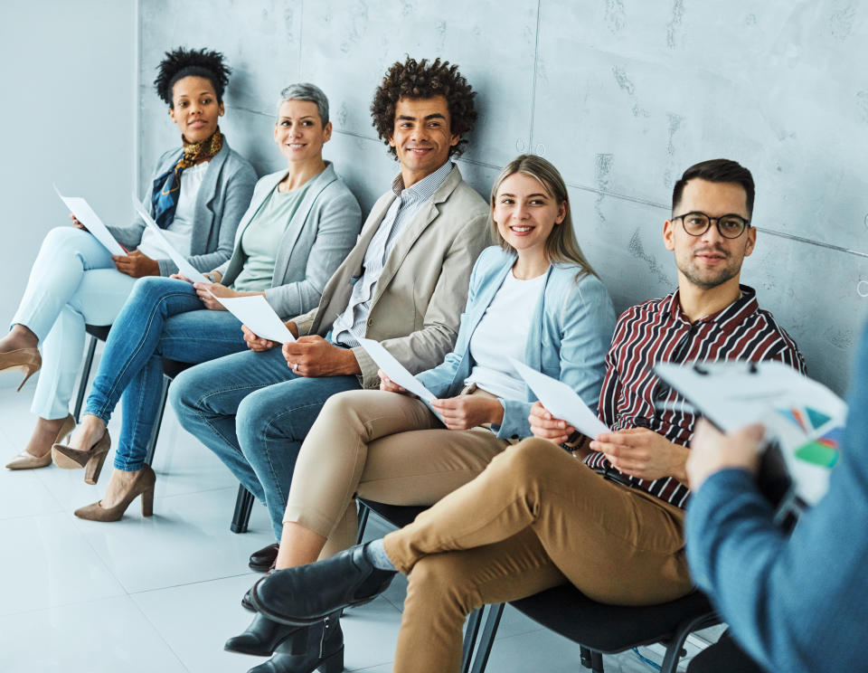 Group of young business people sitting in chairs and waiting for an interview