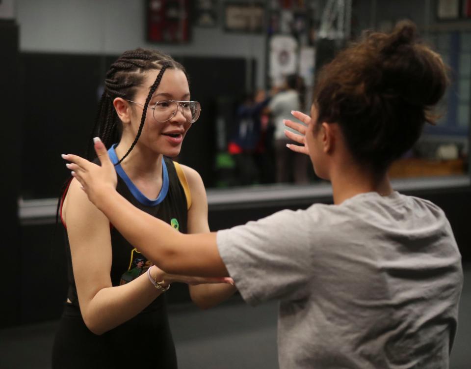 Jazmyn Covington of Smyrna, left, takes the role of an attacker as Adilia Colon of Smyrna fends her off as Girls Unite for Defense members take self-defense training at Delaware Dragon Martial Arts in Newark.