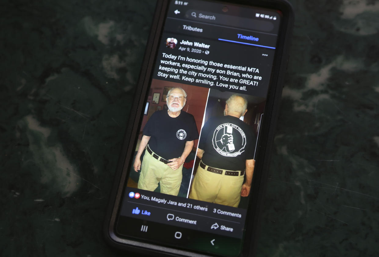 Brian Walter displays a Facebook post from 2020 in which his late father, John Walter, honored essential workers like his son, a New York City Transit employee, Wednesday, April 7, 2021, in the Queens borough of New York. John Walter died of the coronavirus May 10, 2020. (AP Photo/Jessie Wardarski)