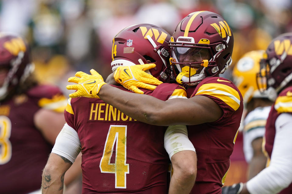 Washington Commanders quarterback Taylor Heinicke (4) and running back Antonio Gibson celebrate connecting for a touchdown during the first half of an NFL football game against the Green Bay Packers, Sunday, Oct. 23, 2022, in Landover, Md. (AP Photo/Susan Walsh)