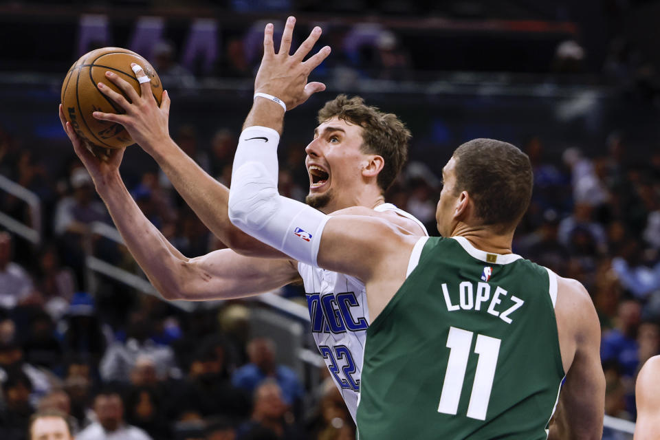 Orlando Magic forward Franz Wagner (22) goes to basket against Milwaukee Bucks center Brook Lopez (11) during the first half of an NBA basketball game Tuesday, March 7, 2023, in Orlando, Fla. (AP Photo/Kevin Kolczynski)