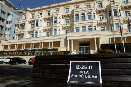 A placard with a Maltese idiom reading: "The truth will always surface" is seen outside Whitehall Mansions, which houses the Maltese-registered Pilatus Bank, in Ta' Xbiex, Malta March 21, 2018. REUTERS/Darrin Zammit Lupi