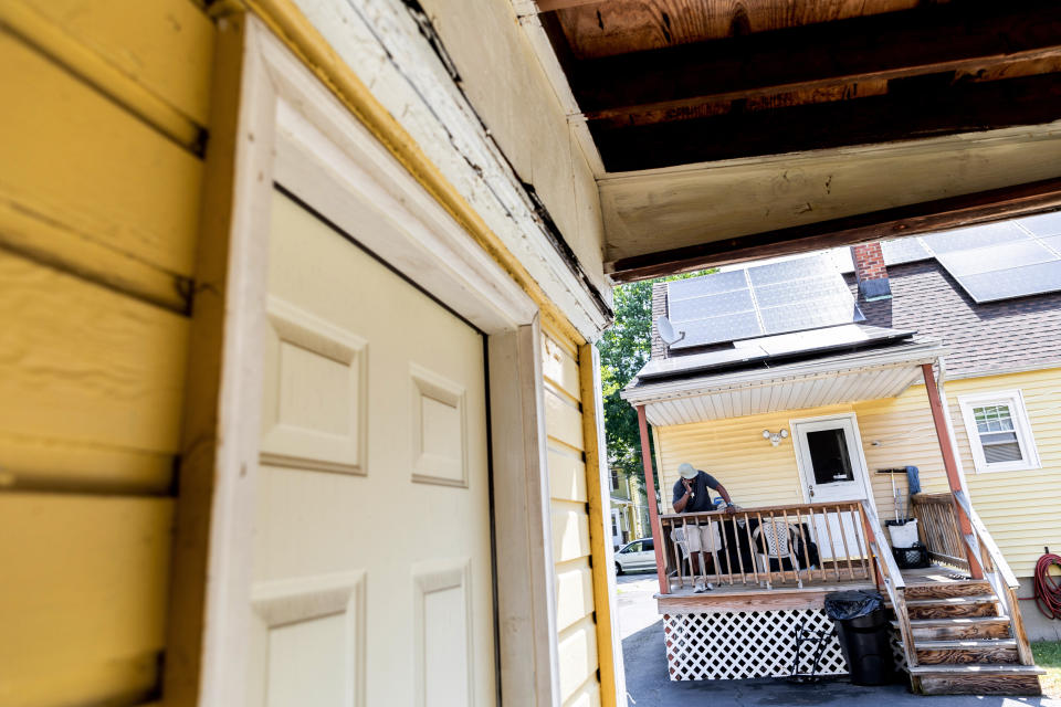 Harold Lewis, a recovering drug user, talks to his girlfriend on the porch of his mother's house, Tuesday, July 19, 2022 in Stratford, Conn. Lewis moved back in with his mother and older sister several months earlier. (AP Photo/Julia Nikhinson)