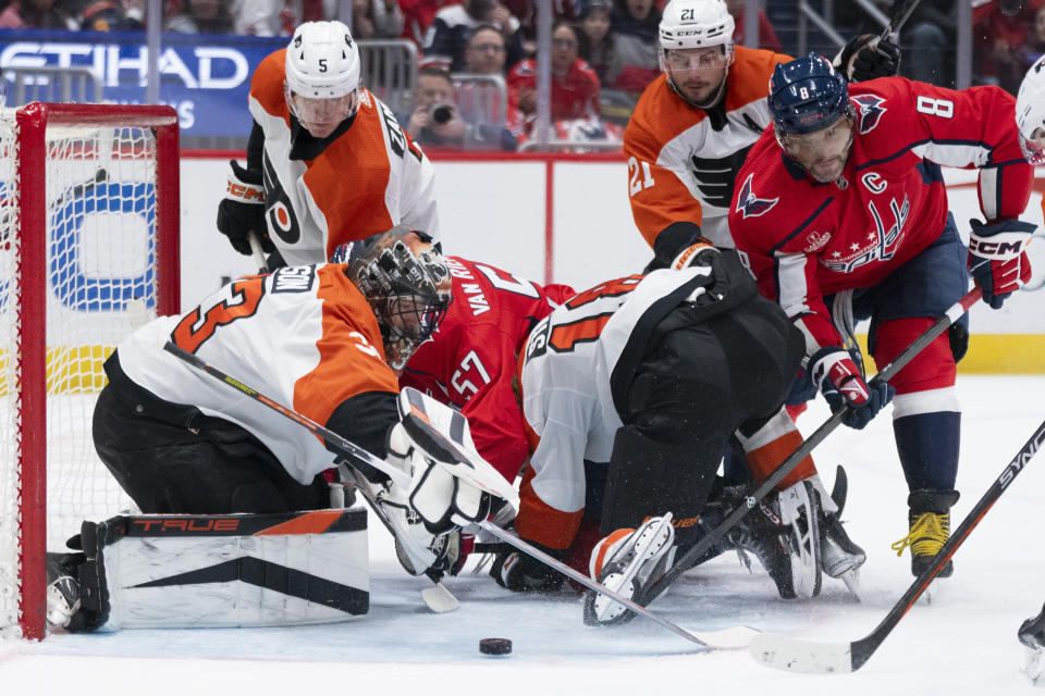 Philadelphia Flyers goaltender Samuel Ersson (33) watches the puck as Washington Capitals left wing Alex Ovechkin (8) reaches for it during the first period of an NHL hockey game Friday, March 1, 2024, in Washington. (AP Photo/Manuel Balce Ceneta)