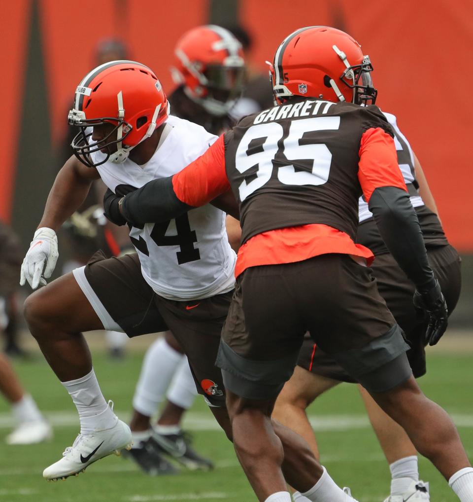 Cleveland Browns running back Nick Chubb, left, attempts to break away from defensive end Myles Garrett during training camp July 29, 2021, in Berea.