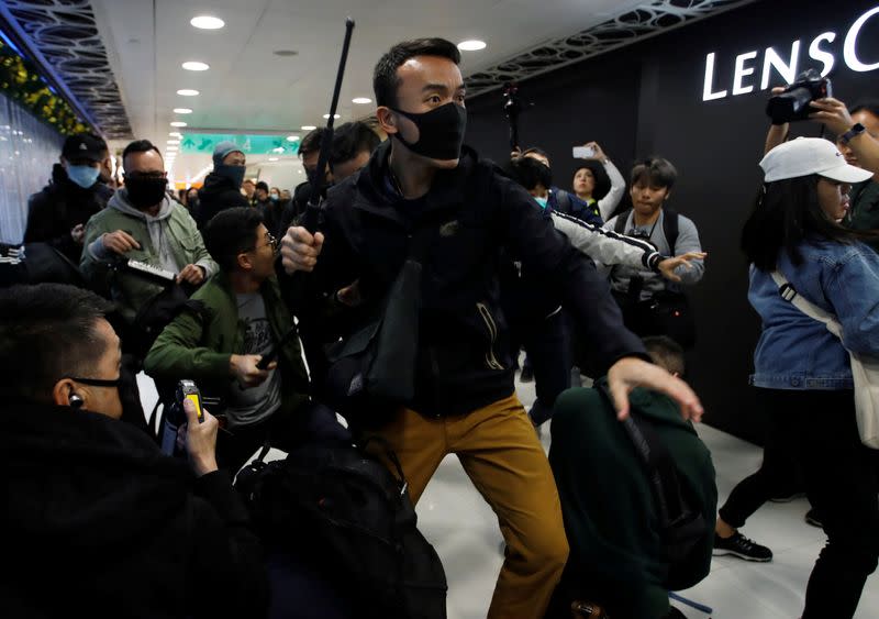 A plain-cloth police officer clash with anti-government protesters inside the Sheung Shui shopping mall in Hong Kong