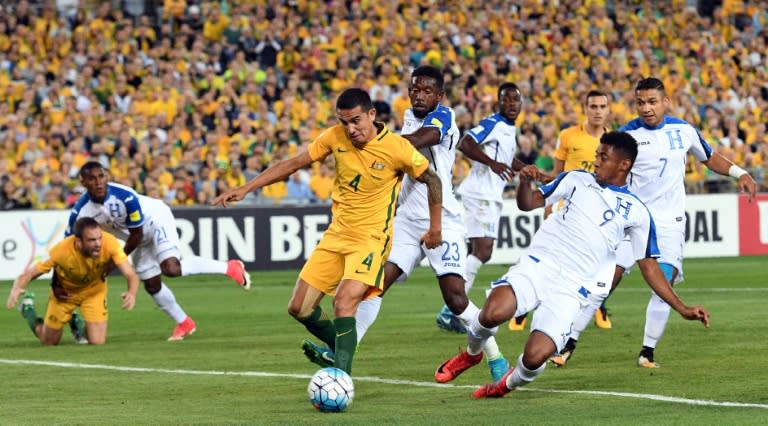 Australia's Tim Cahill (C) shoots on goal as he is tackled by Honduras' players during their FIFA 2018 World Cup qualification play-off 2nd leg match, in Sydney, on November 15, 2017