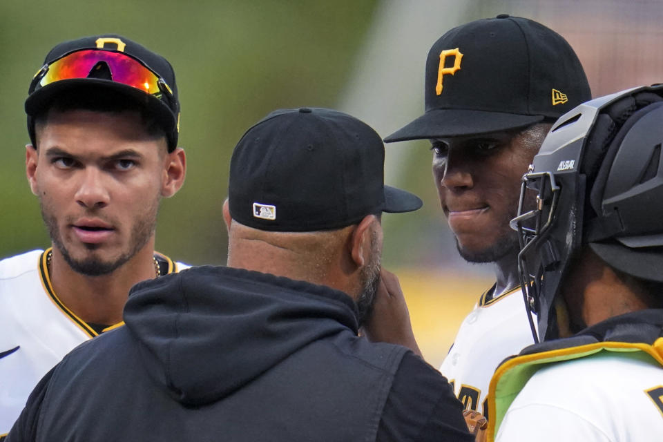Pittsburgh Pirates starting pitcher Roansy Contreras, second from right, listens to pitching coach Oscar Marin during a mound visit in the second inning of the team's baseball game against the Milwaukee Brewers in Pittsburgh, Friday, July 1, 2022. (AP Photo/Gene J. Puskar)