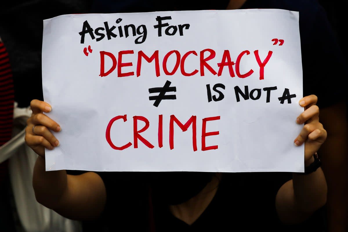 File: A pro-democracy protester holds a placard ‘Asking For Democracy Is Not A Crime’ during an anti-government protest in Bangkok (EPA)