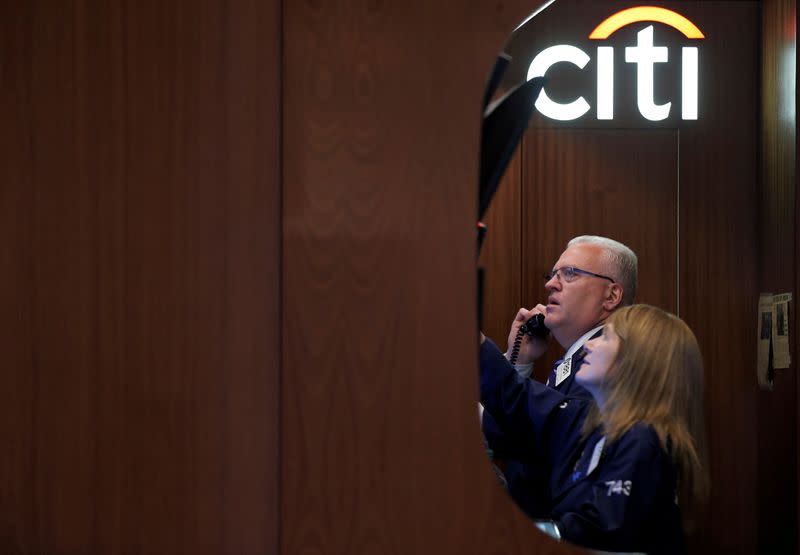 FILE PHOTO: Traders work in the Citigroup booth on the floor of the NYSE in New York