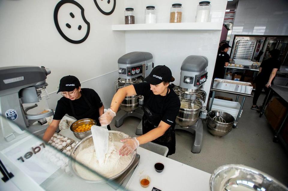 Bakers Micaela Garcia, 20, left, and Zoe, 18, right, prepare dough for Molten Lava cookies at Crumbl Cookies, located at 3630 G Street, Suite E, in the new Yosemite Crossing shopping center in Merced, Calif., on Wednesday, June 7, 2023. The location’s grand opening is scheduled for June 9.