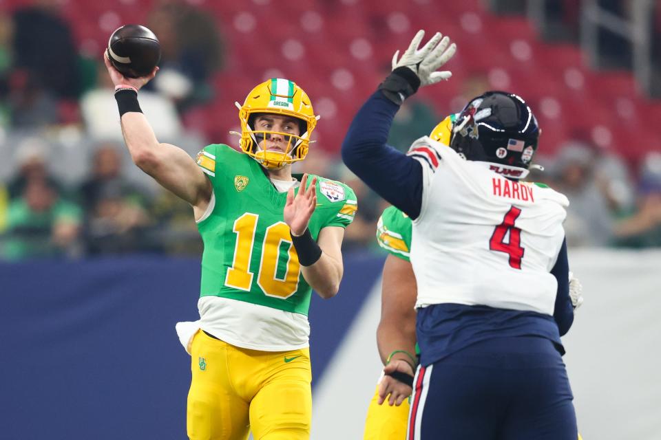 Oregon Ducks quarterback Bo Nix (10) throws the ball under pressure from Liberty Flames defensive tackle Jay Hardy (4) during the first quarter of the 2024 Fiesta Bowl at State Farm Stadium Jan. 1, 2024, in  Glendale, Arizona.