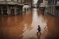 A man wades through an area flooded by heavy rains, in Porto Alegre, Rio Grande do Sul state, Brazil, Friday, May 3, 2024. (AP Photo/Carlos Macedo)