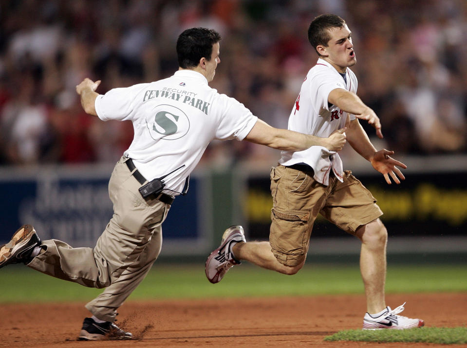 Tom McMahon of the Fenway Park Security team chases down a fan who ran on the field as Manny Ramirez of the Boston Red Sox was up to bat in the eighth inning against the Cleveland Indians on May 30, 2007 at Fenway Park in Boston, Massachusetts. (Photo by Elsa/Getty Images)
