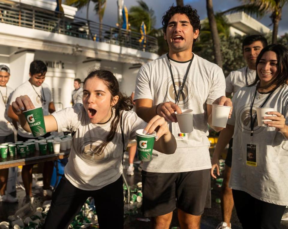 Volunteer Maria Lorenzo cheers runners stopping at her water station on Ocean Drive while participating in the Life Time Miami Marathon and Half Marathon on Sunday, Jan. 29, 2023, in Miami Beach, Fla.