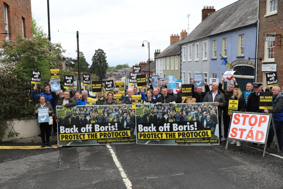 FILE - Demonstrators protest outside Hillsborough Castle, ahead of a visit by British Prime Minister Boris Johnson, in Hillsborough, Northern Ireland, May, 16, 2022. Outgoing U.K. Prime Minister Boris Johnson has been the bane of Brussels for many years, from his days stoking anti-European Union sentiment with exaggerated newspaper stories to his populist campaign leading Britain out of the bloc and reneging on the post-Brexit trade deal he himself signed. (AP Photo/Peter Morrison, file)