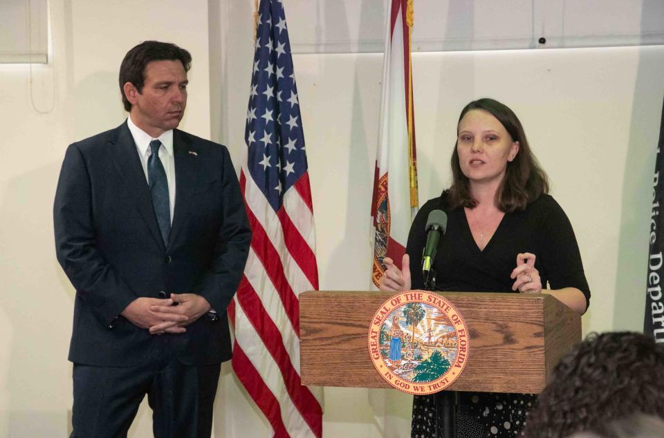 Gov. Ron DeSantis listens to remarks from one of Jeffrey Epstein's victims, Jena-Lisa Jones, before signing the bill.