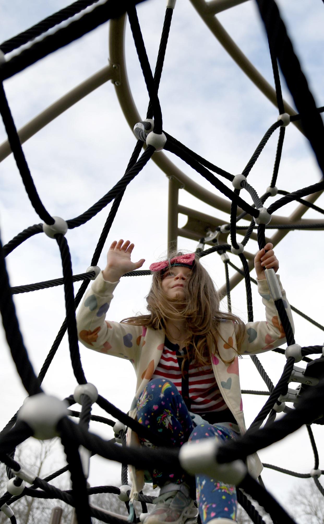 Sophia Devitto-Skiles, 6, of Canton climbs at the Dogwood Possibility Playground in North Canton on an unseasonably warm December day.