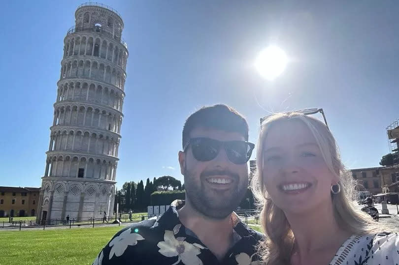 The photo shows Emily and her husband next to the tower