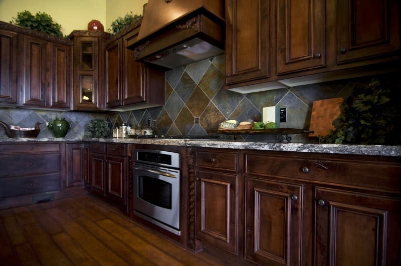 Luxurious kitchen with hard wood flooring and dark wood cabinets