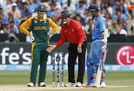 South Africa's wicketkeeper Quinton de Kockas (L) and India's Ajinkya Rahane (R) watch as umpire Aleem Dar sets the stumps, during their Cricket World Cup match at the Melbourne Cricket Ground (MCG), February 22, 2015. REUTERS/Brandon Malone