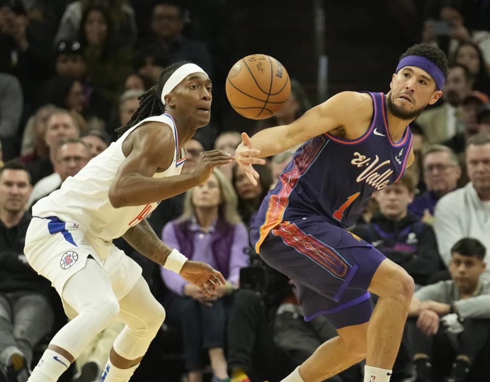 LA Clippers guard Terance Mann (14) steals the ball from Phoenix Suns guard Devin Booker (1) during the second quarter at Footprint Center in Phoenix on Jan. 3, 2024.