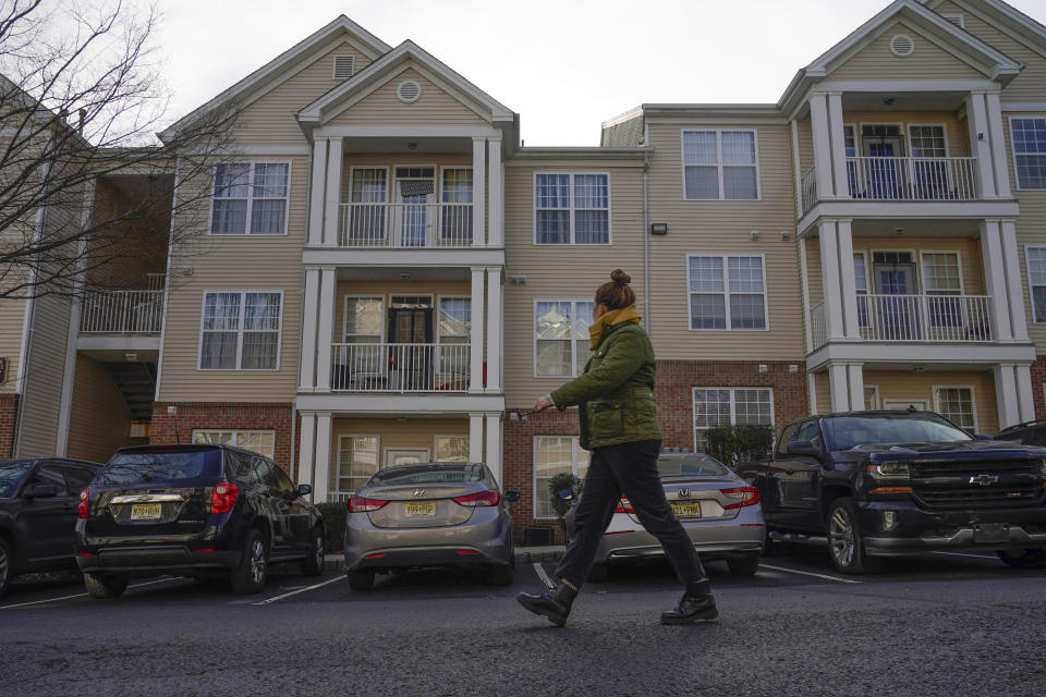 A woman walks past the home of Sayreville councilwoman Eunice Dwumfour in a townhome community in the Parlin area of Sayreville, N.J., Thursday, Feb. 2, 2023. Dwumfour was found shot to death in an SUV parked outside her home on Wednesday. According to the Middlesex County prosecutor's office, she had been shot multiple times and was pronounced dead at the scene. (AP Photo/Seth Wenig)