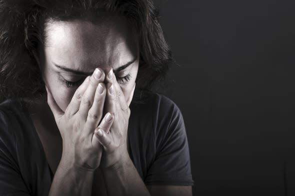 Depressed woman on black background