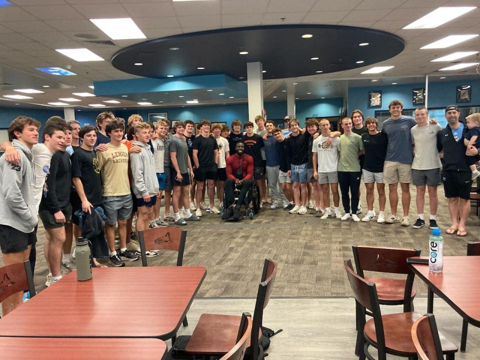 Patric Young, center in wheelchair, with members of the Ponte Vedra High lacrosse team Monday after giving an inspirational talk to the Sharks on Monday. Young was paralyzed nearly 20 months ago from a single-vehicle accident in Nebraska, just 10 days before his scheduled wedding.