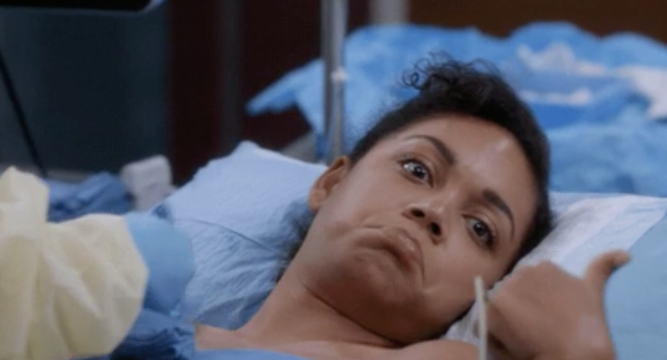 close up of a person in a hospital bed giving the thumbs up