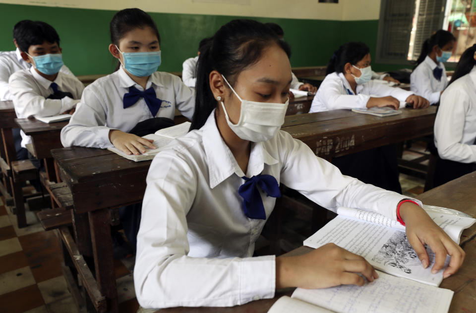 Students sit in their class room at Santhormok high school, in Phnom Penh, Cambodia, Monday, Nov. 2, 2020. Schools throughout Cambodia that had been shut in March because of the coronavirus crisis reopened Monday, but with limits on class sizes and hours.(AP Photo/Heng Sinith)