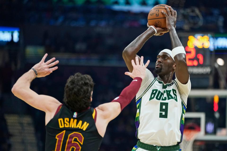 Milwaukee Bucks' Bobby Portis (9) shoots over Cleveland Cavaliers' Cedi Osman (16) in the first half of an NBA basketball game, Wednesday, Jan. 26, 2022, in Cleveland. (AP Photo/Tony Dejak)