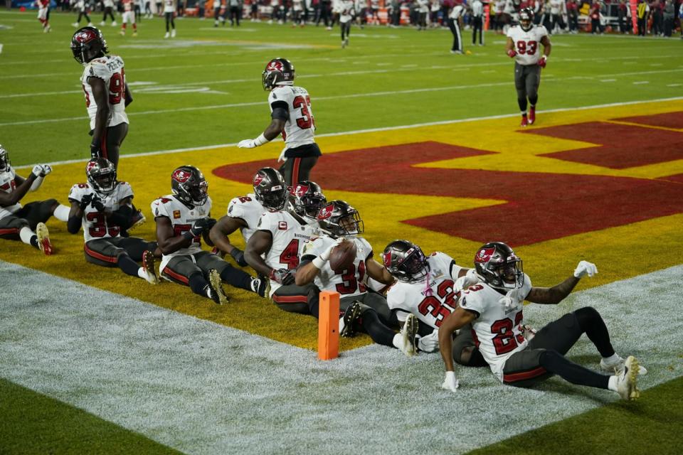 Tampa Bay Buccaneers strong safety Antoine Winfield Jr., holding the ball, celebrates with teammates.