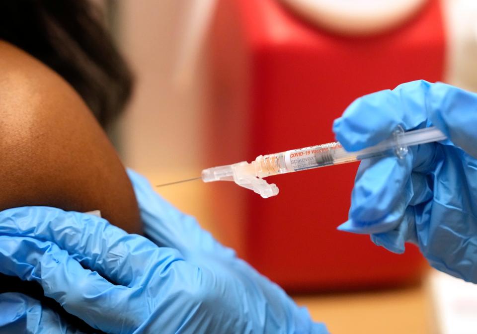 A pharmacist administers a Moderna Spikevax COVID-19 vaccine last month at a drug store in Cypress, Texas.