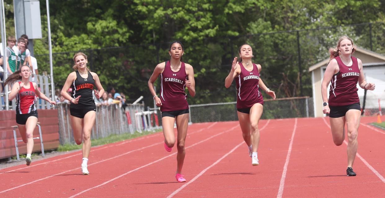 Scarsdale's Maria Roberts (r) and teammates Leia Patel (third from left) and Ari Sobel (second from right) compete in the girls 400 during the Somers Lions Club Joe Wynne Invitational track and field meet at Somers High School May 4, 2024. Scarsdale swept the first three spots with Roberts first, Patel second and Sobel third.