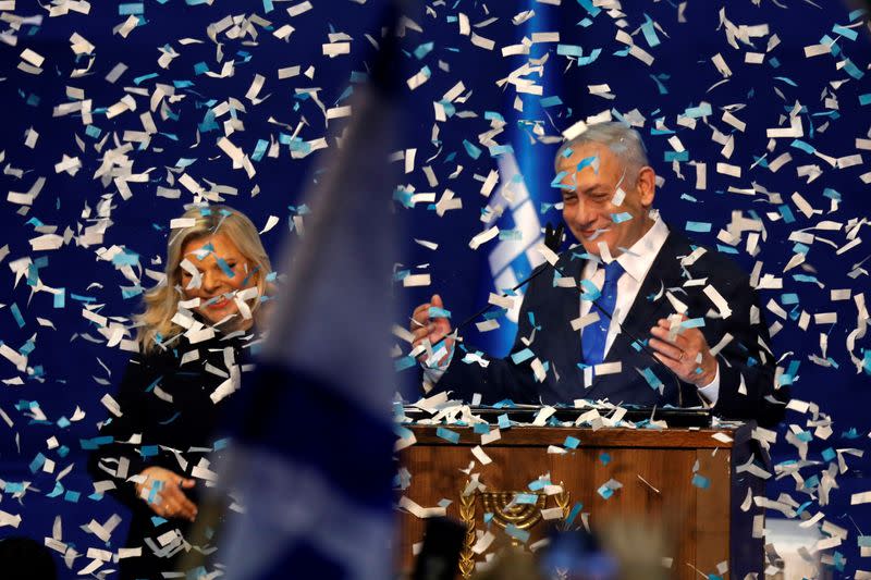 Confetti falls as Israeli Prime Minister Benjamin Netanyahu stands next to his wife Sara after speaking to supporters following the announcement of exit polls in Israel's election at his Likud party headquarters in Tel Aviv