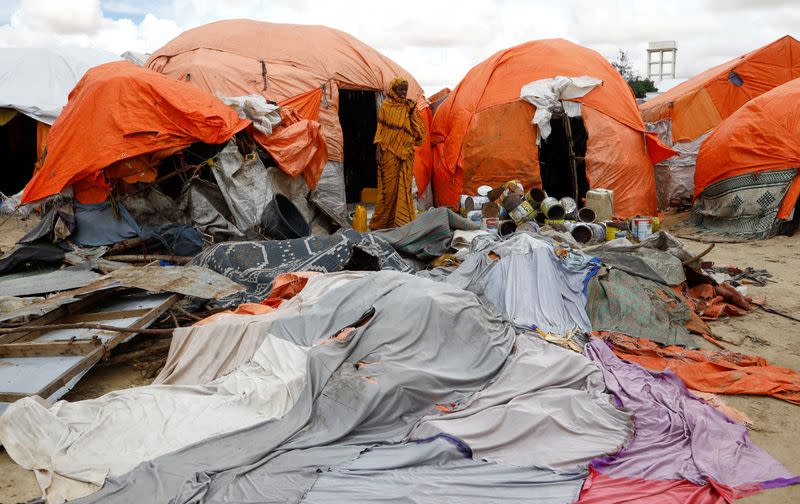 An internally displaced Somali woman stands near makeshift shelters destroyed following heavy rains at the Al Hidaya camp for the internally displaced people on the outskirts of Mogadishu