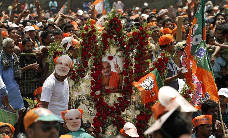 Supporters of the main opposition Bharatiya Janata Party wear masks of their prime ministerial candidate Narendra Modi during an election campaign in Balasore, about 200 kilometers (125 miles) from Bhubaneswar, India, Friday, April 11, 2014. The multiphase voting across the country runs until May 12, with results for the 543-seat lower house of Parliament announced May 16. (AP Photo/Biswaranjan Rout)