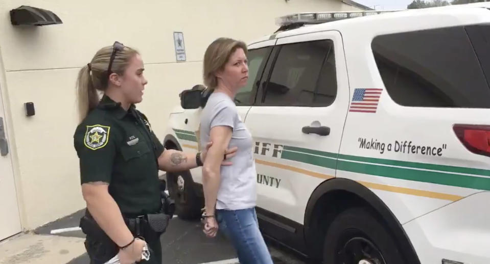 Sarah Boone, 42, is pictured being led away by a police officer.