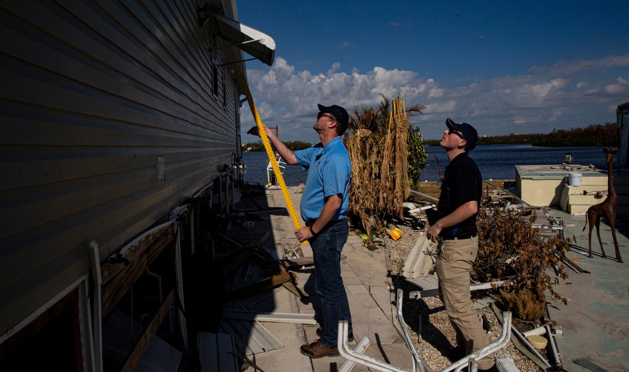 Rodney Wynn and Austen Flannery, both meteorologist for the National Weather Service assess Hurricane Ian damage including storm surge heights on homes on San Carlos Island next to Fort Myers Beach on Tuesday, Oct. 4, 2022. 