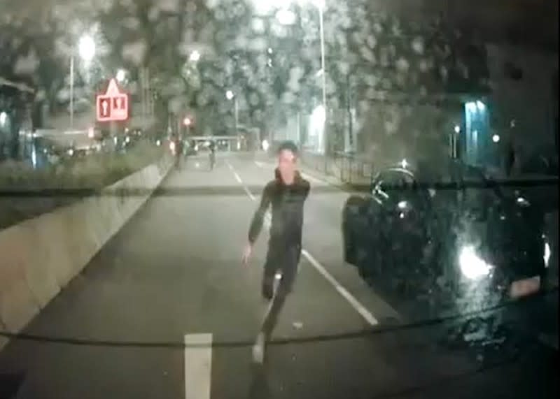 一名手持電筒男子從私家車跑出。
