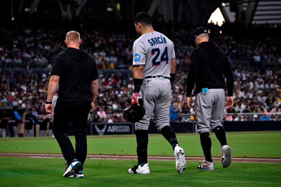 Aug 22, 2023; San Diego, California, USA; Miami Marlins left fielder Avisail Garcia (24) is accompanied by trainers to the dugout after grounding out against the San Diego Padres during the third inning at Petco Park.