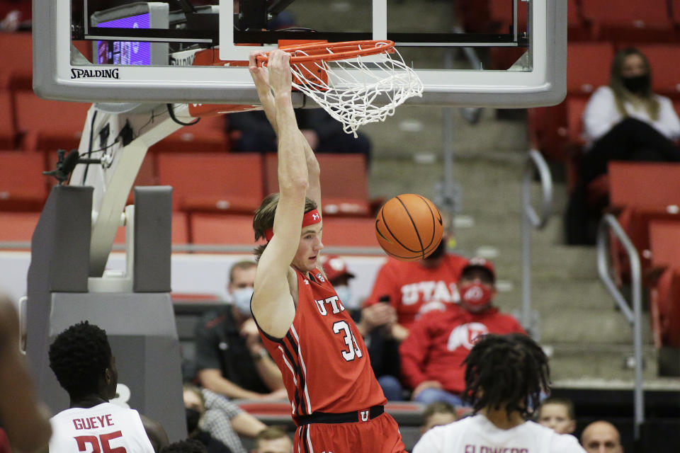 FILE - Utah center Branden Carlson dunks during the first half of an NCAA college basketball game against Washington State, Wednesday, Jan. 26, 2022, in Pullman, Wash. “This team has the mindset that we’re just going to be physical this year,” senior center Branden Carlson said. “We’re not going to get pushed around.” (AP Photo/Young Kwak, File)