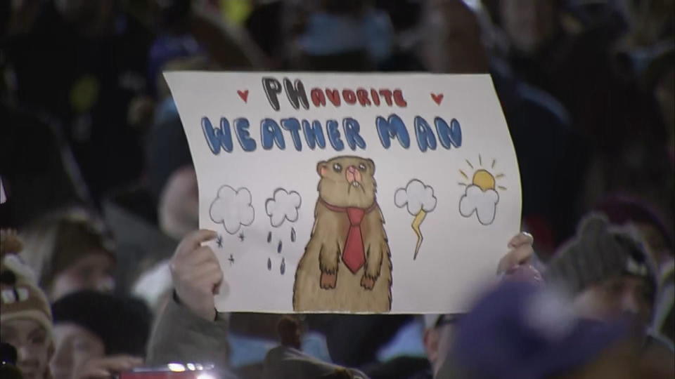 A person in the crowd at Gobbler's Knob in Punxsutawney, Pa. holds a sign reading 