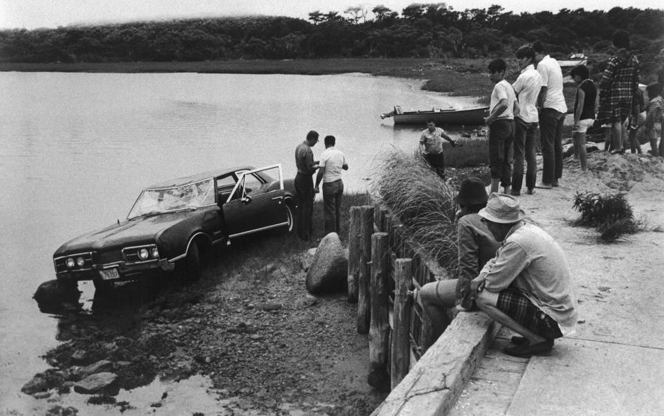 Spectators look on as police work near the car driven by Sen. Edward Kennedy of Massachusetts which plunged off a bridge in an island pond on July 19, 1969, Chappaquiddick Island near Edgartown, Martha’s Vineyard, Mass. (Photo: Bettmann/Getty Images)