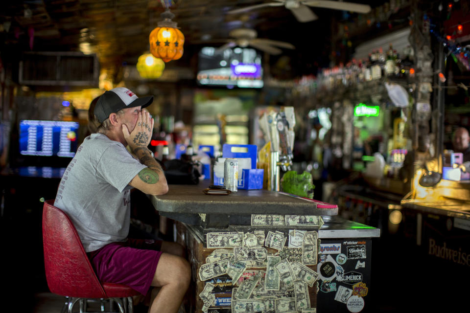 Andrew Parker watches the latest on Hurricane Dorian from the bar at Huc-A-Poos pizza restaurant, Wednesday, Sept. 4, 2019, in Tybee Island, Ga. Parker said he's been through eight hurricanes in his lifetime as a resident of Tybee. And like the others Parker said he plans on riding Dorian out at his home on the island. (AP Photo/Stephen B. Morton)