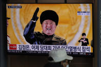 A man wearing a face mask sits in front of a TV screen showing North Korean leader Kim Jong Un, at the Seoul Railway Station in Seoul, South Korea, Friday, Jan. 15, 2021. The letters read "Kim Jong Un attended stage in Thursday night's parade celebrating a ruling party congress." (AP Photo/Lee Jin-man)