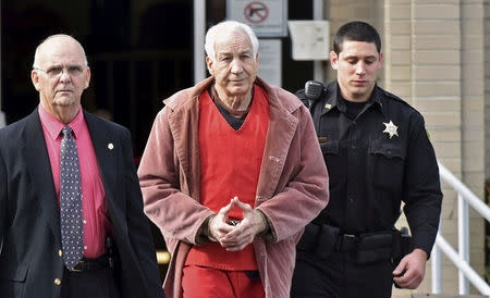 FILE PHOTO: Convicted child molester Jerry Sandusky (C), a former assistant football coach at Penn State University, leaves after his appeal hearing at the Centre County Courthouse in Bellefonte, Pennsylvania, U.S. on October 29, 2015. REUTERS/Pat Little/File Photo